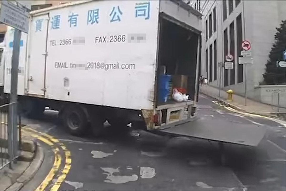 一輛密斗貨車在西營盤行車期間，未有收起貨車尾板。(FB群組「車cam L（香港群組）」影片截圖)