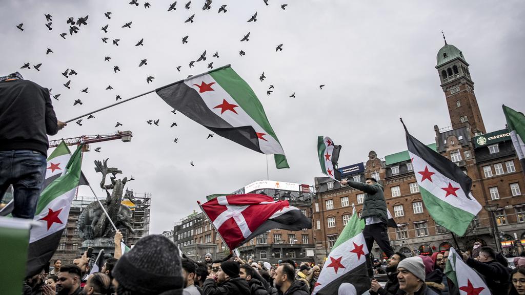 丹麥首都哥本哈根有民眾上街，慶祝巴沙爾政權倒台。(美聯社)