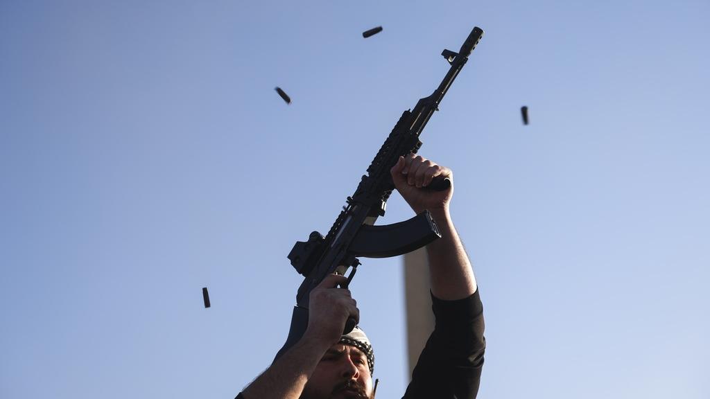 敘利亞反政府武裝分子周日在大馬士革街頭開槍慶祝巴沙爾倒台。(美聯社)