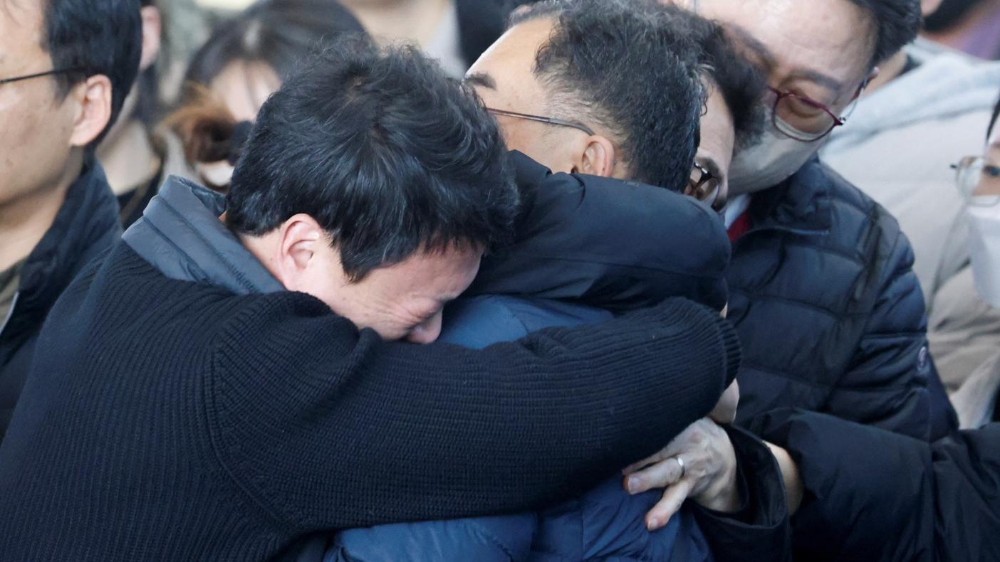 家屬在務安機場抱頭痛哭。(路透社)