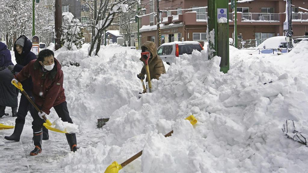 北海道釧路居民周二忙於清理街上厚厚的積雪。(美聯社)