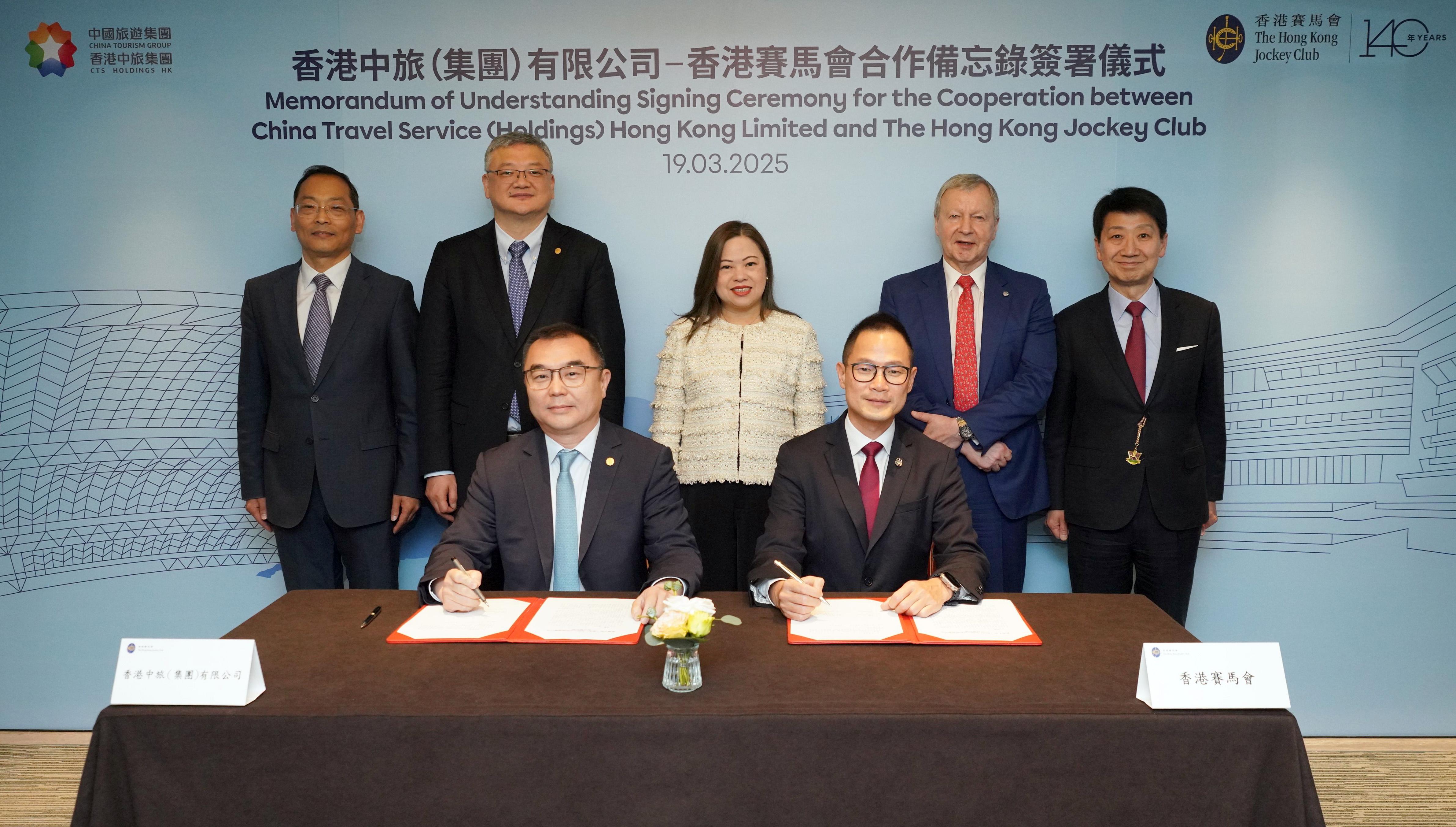 在香港特別行政區政府文化體育及旅遊局局長羅淑佩（後排中），中聯辦經濟部副部長郭韶偉（後排左一），香港旅遊發展局主席彭耀佳（後排右一），香港賽馬會行政總裁應家柏（後排右二），及香港中旅（集團）有限公司董事長王海民（後排左二）的見證下，香港賽馬會客戶策略、體驗及創新事務執行總監侯德洋（前排右）與香港中旅（集團）有限公司副總經理簡易（前排左）代表雙方簽署合作備忘錄，加強在旅遊、體育、文化及青年發展的戰略合作。