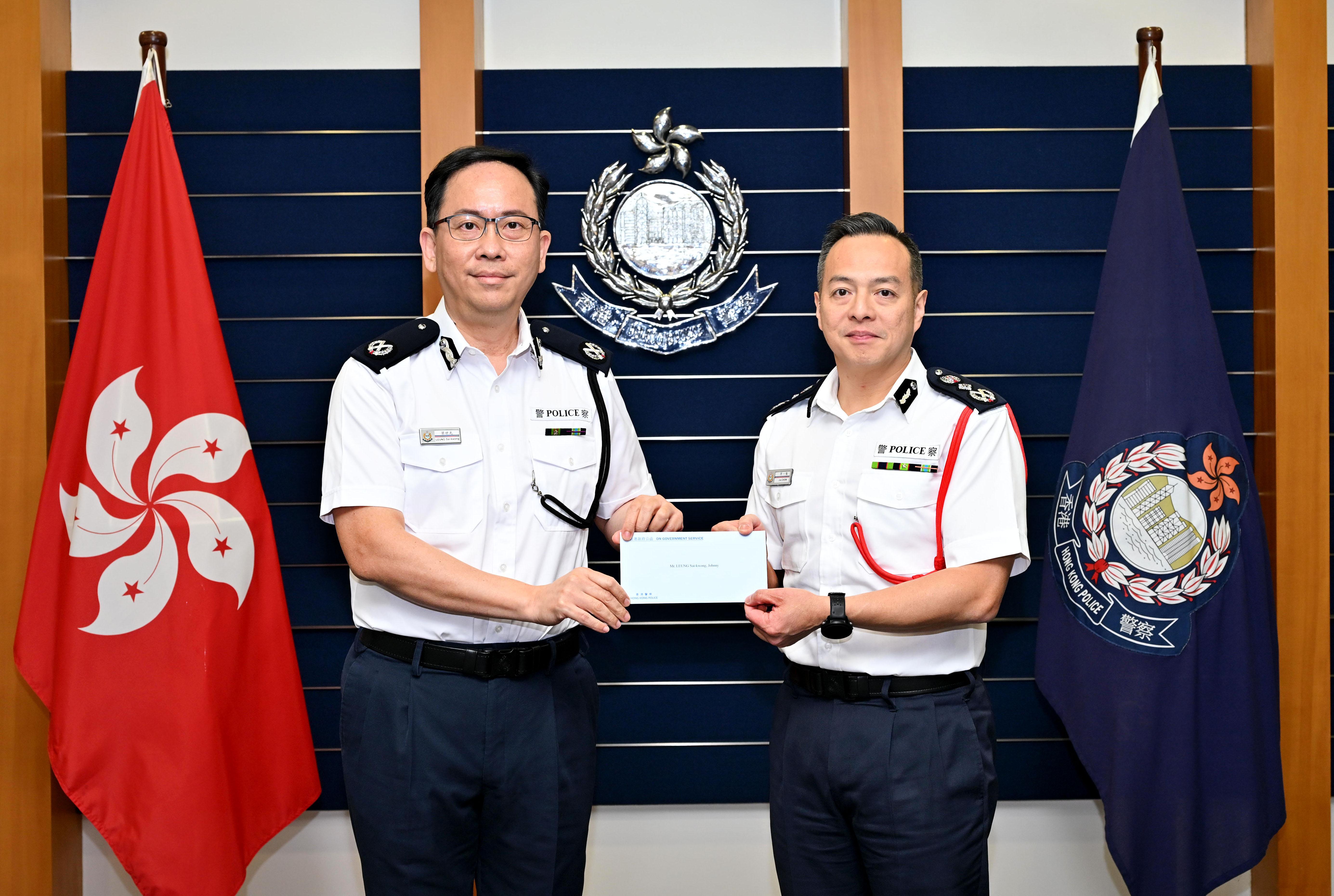 警務處處長周一鳴（右）頒授委任狀予新委任香港輔助警察隊總監梁世光（左）。(政府新聞處)