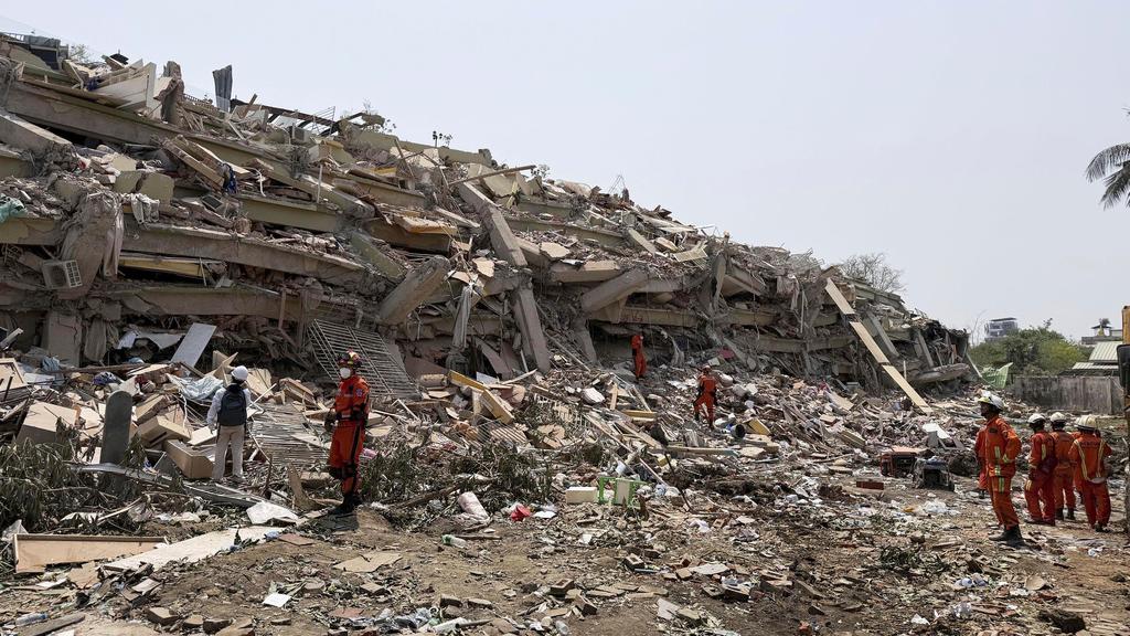 緬甸地震災情慘重，圖為救援隊周一在曼德勒倒塌的天空別墅公寓大樓搜救。(美聯社)