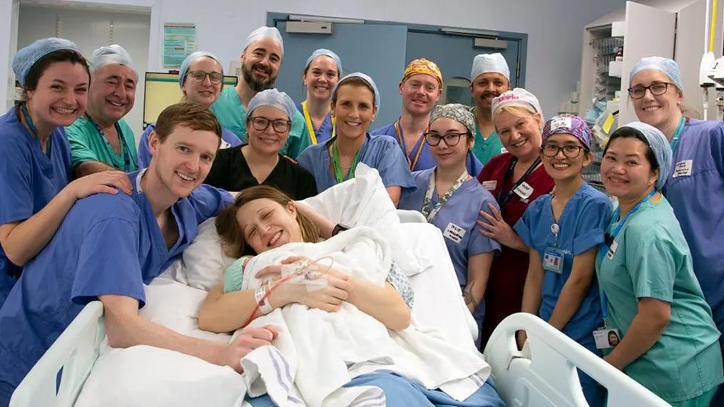 戴維森移植由姊姊捐贈的子宮後，今年2月在倫敦一間醫院誕下女兒，前排左1是丈夫安格斯。(互聯網)