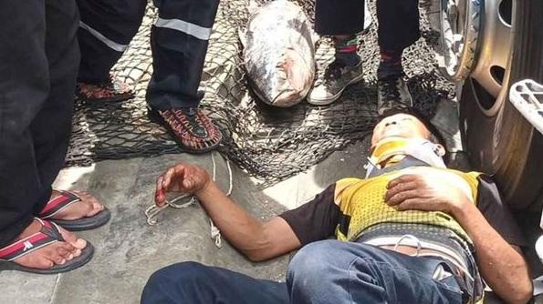 貨車司機被吞拿魚砸中頭部，受傷倒地，旁人即時幫他固定頸部待救。(互聯網)