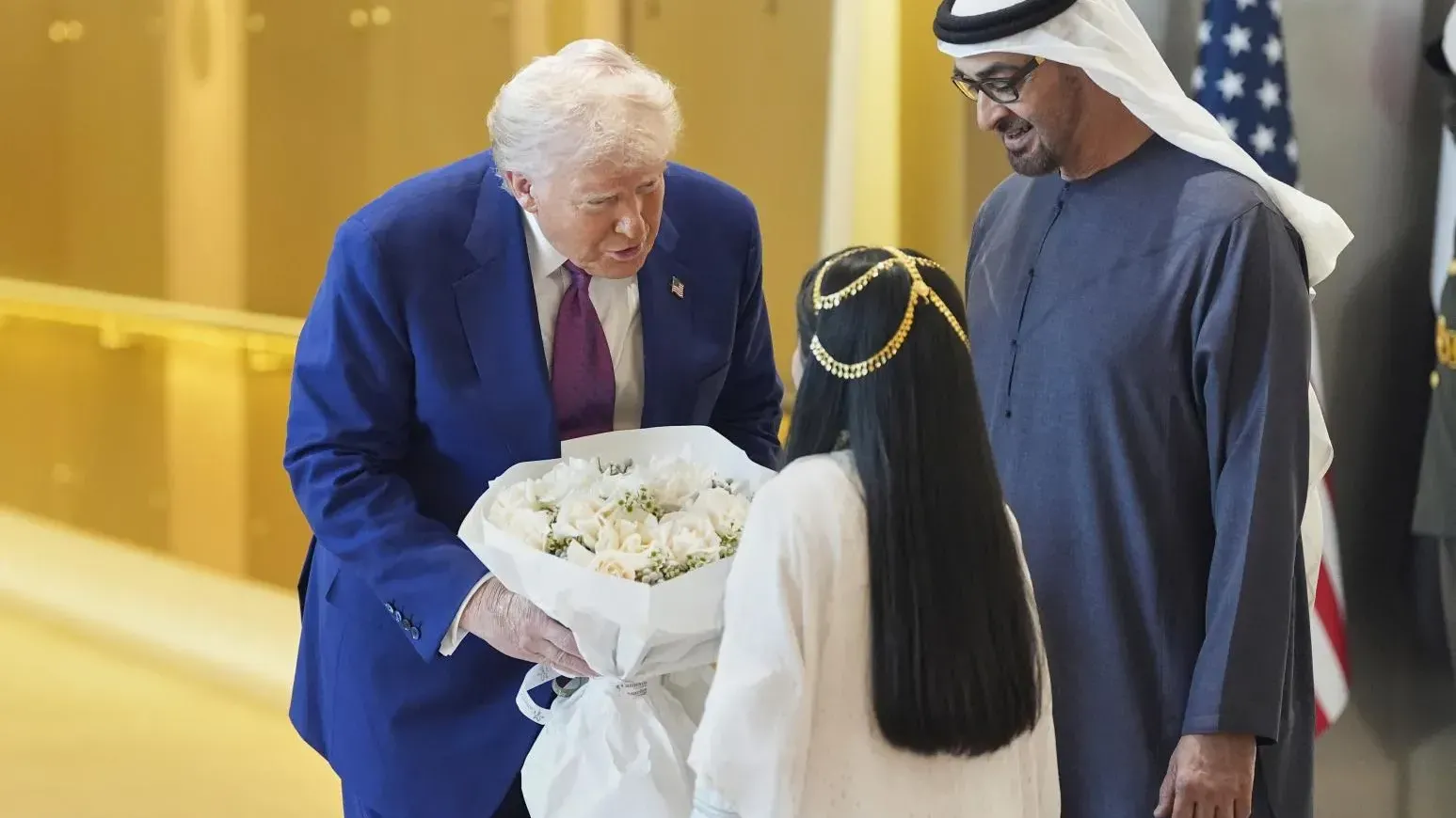 特朗普（左）訪問阿拉伯聯合酋長國，接受一名女孩獻花。（圖/美聯社）