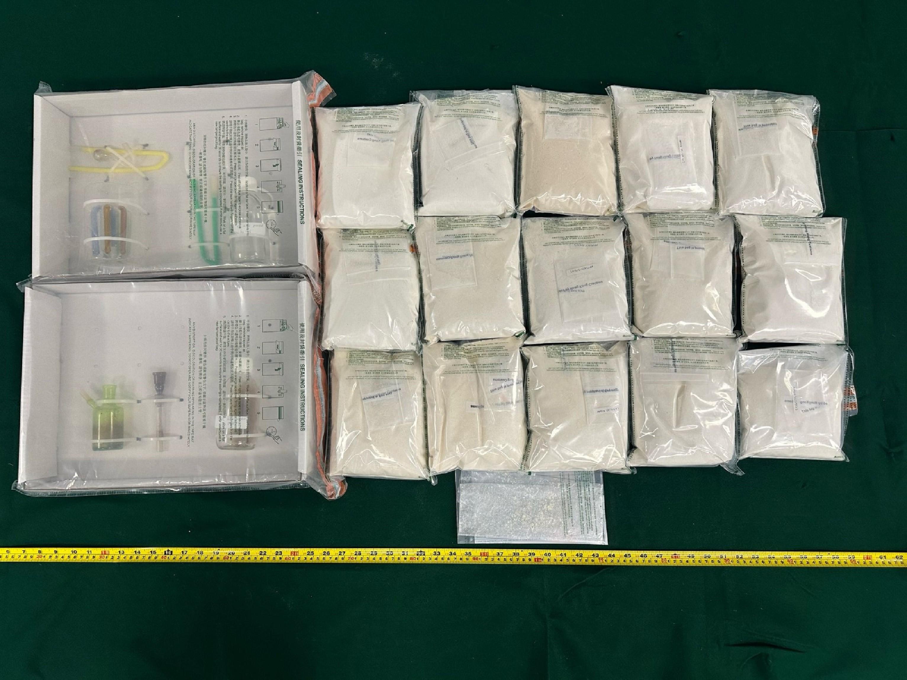 香港海關昨日（五月三日）在荃灣及牛頭角檢獲約十五公斤懷疑依托咪酯，一批毒品吸食器具，估計市值約一千四百萬元。圖示檢獲的懷疑依托咪酯粉末及毒品吸食器具。