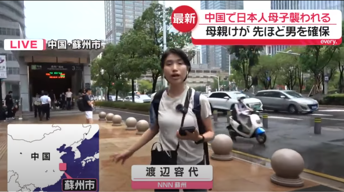 日本電視台記者在蘇州地鐵站外報道。（電視畫面）