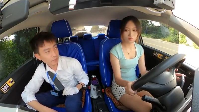 考牌官狂𥄫女考生心口，她會錯意開車即「肥佬」。(微博)