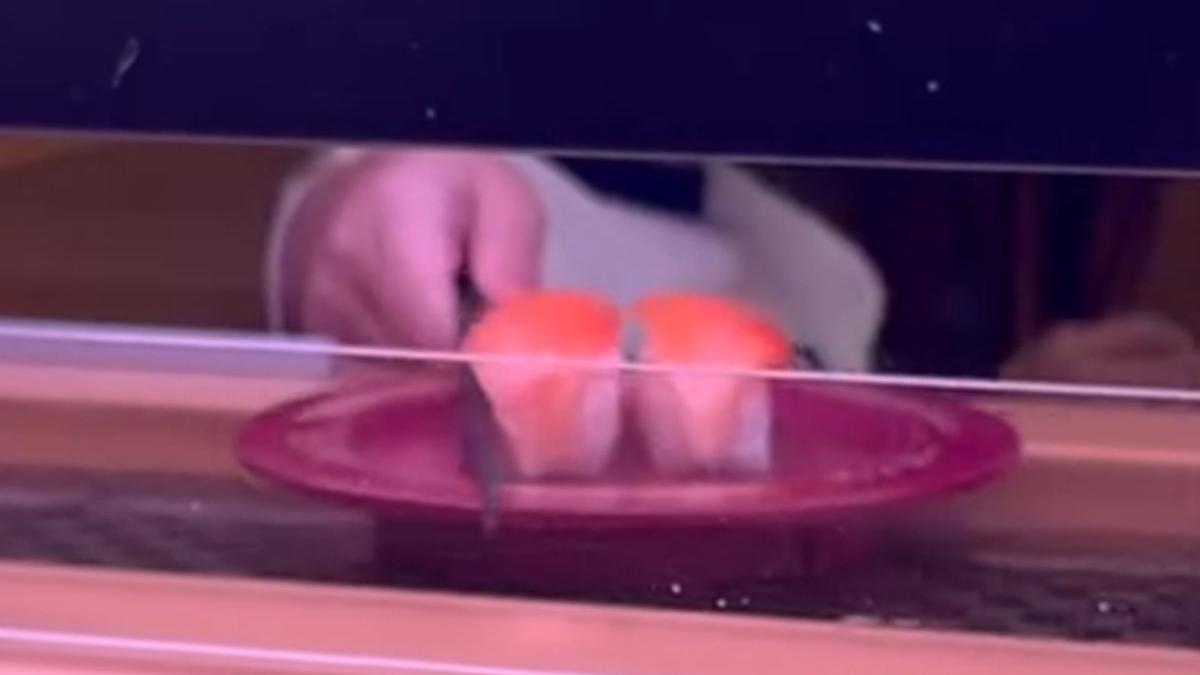 台中一間壽司郎有兒童把筷子伸到迴轉帶上，擋住一碟三文魚壽司。(Threads用戶rain__0808__影片截圖)