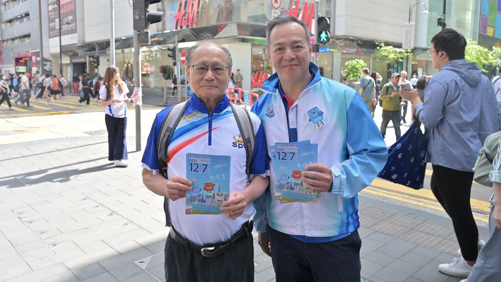 警務處處長周一鳴(右)落區派發紀念品，呼籲市民踴躍投票