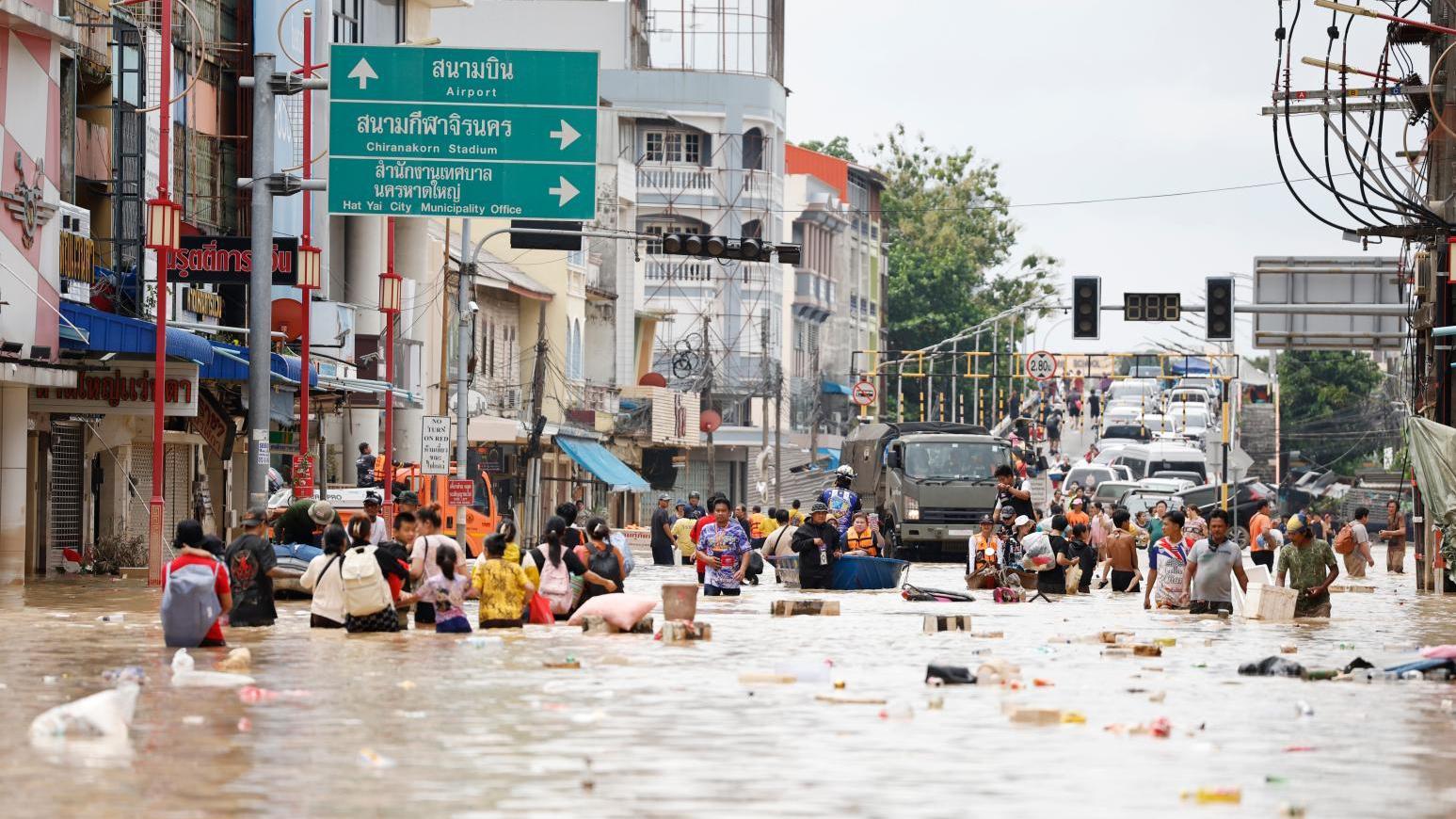 11月27日，泰國南部宋卡府（Songkhla），人們在洪水中跋涉。（圖／美聯社）