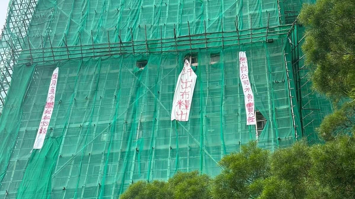 火炭穗禾苑棚網外有人掛上「有汗出冇糧出」、「五月至今還我血汗錢」、「無良公司不負責任」白布直幡。(民建聯沙田區議員陳壇丹fb)