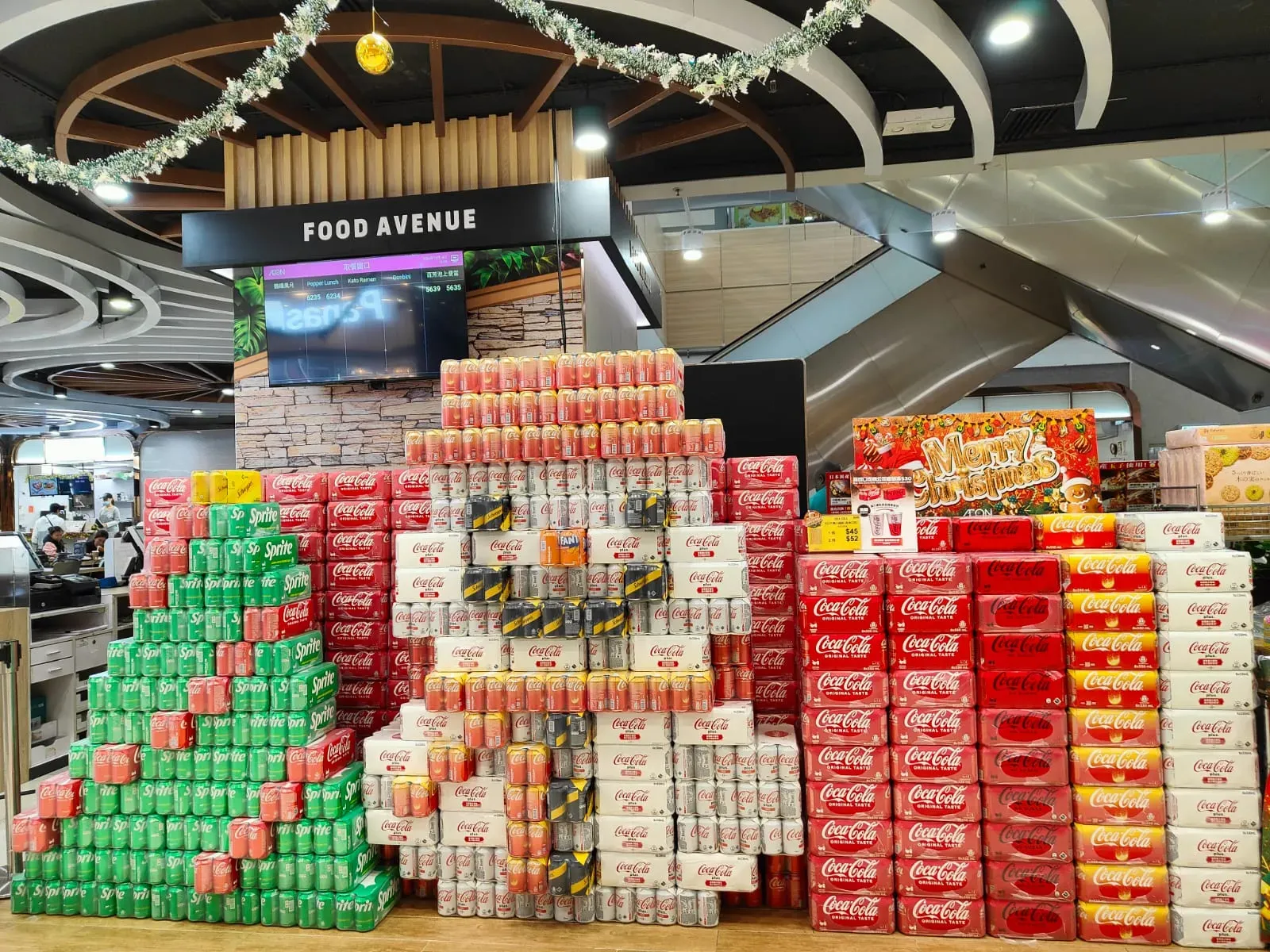 連鎖超市AEON荃灣有員工「大展身手」，以罐裝飲品砌出「微笑雪人」及聖誕樹，創意設計引發社交平台熱議，AEON官方社交平台並轉載照片。(Threads)