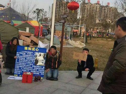 男女騙徒跪地乞討 河南城管舉牌提示